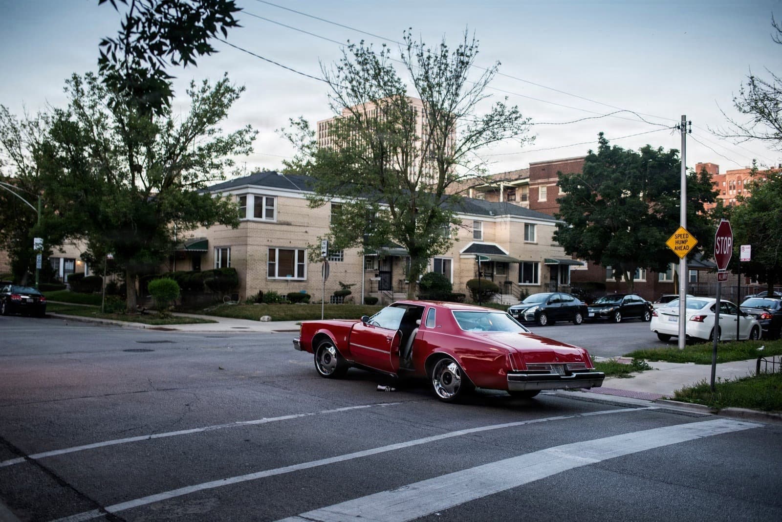 Red classic car with open door at Chicago's South Shore intersection
